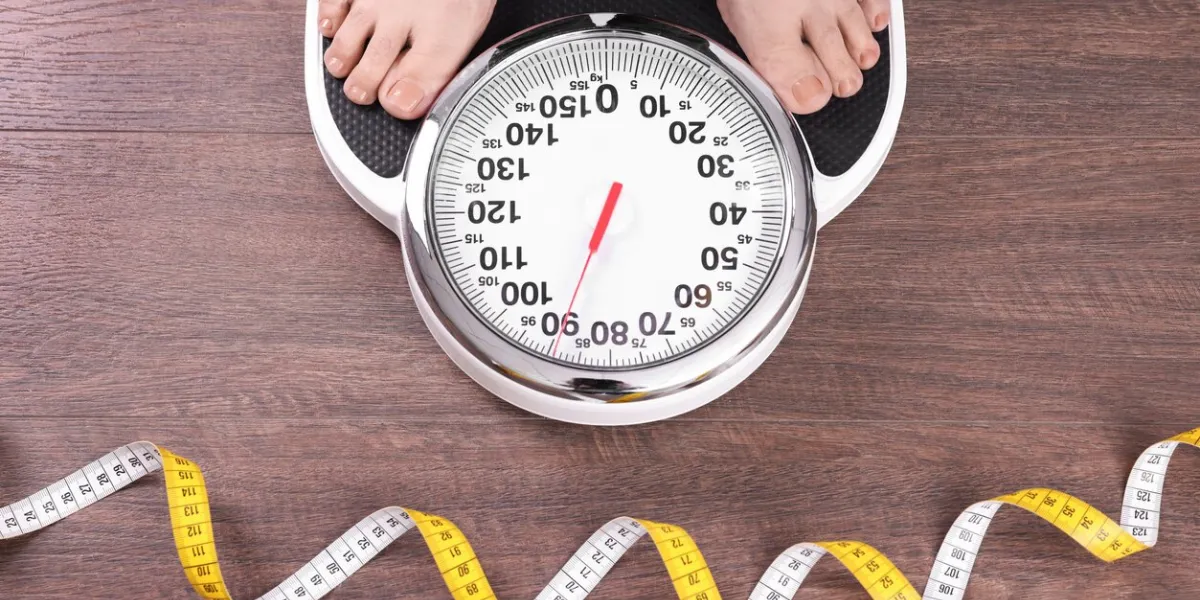 closeup of woman using scales on floor near measuring tape, top view overweight problem