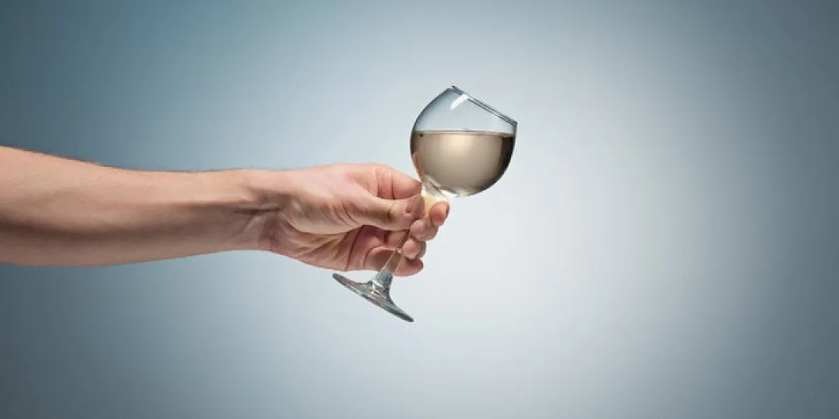 close-up view of white wine glass in male hand