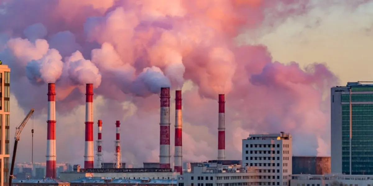 steam or smoke comes from the pipes combined heat and power plant in the city landscape at sunset or dawn