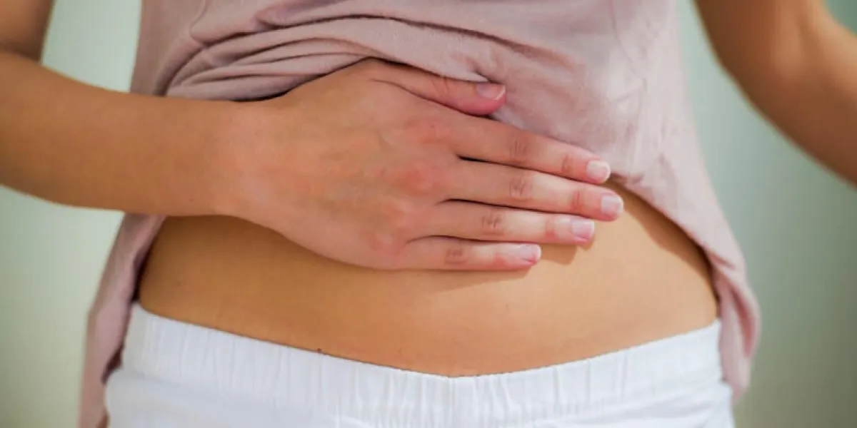 femme avec la main sur le ventre