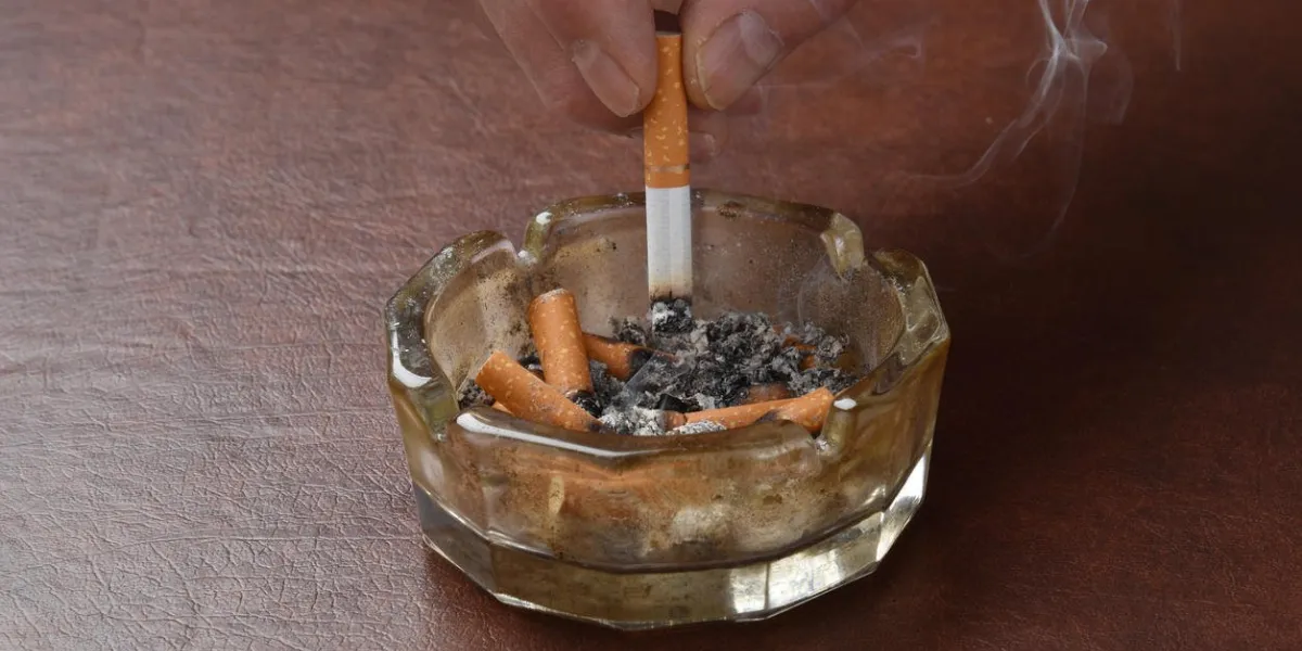 écraser une cigarette dans un cendrier sale