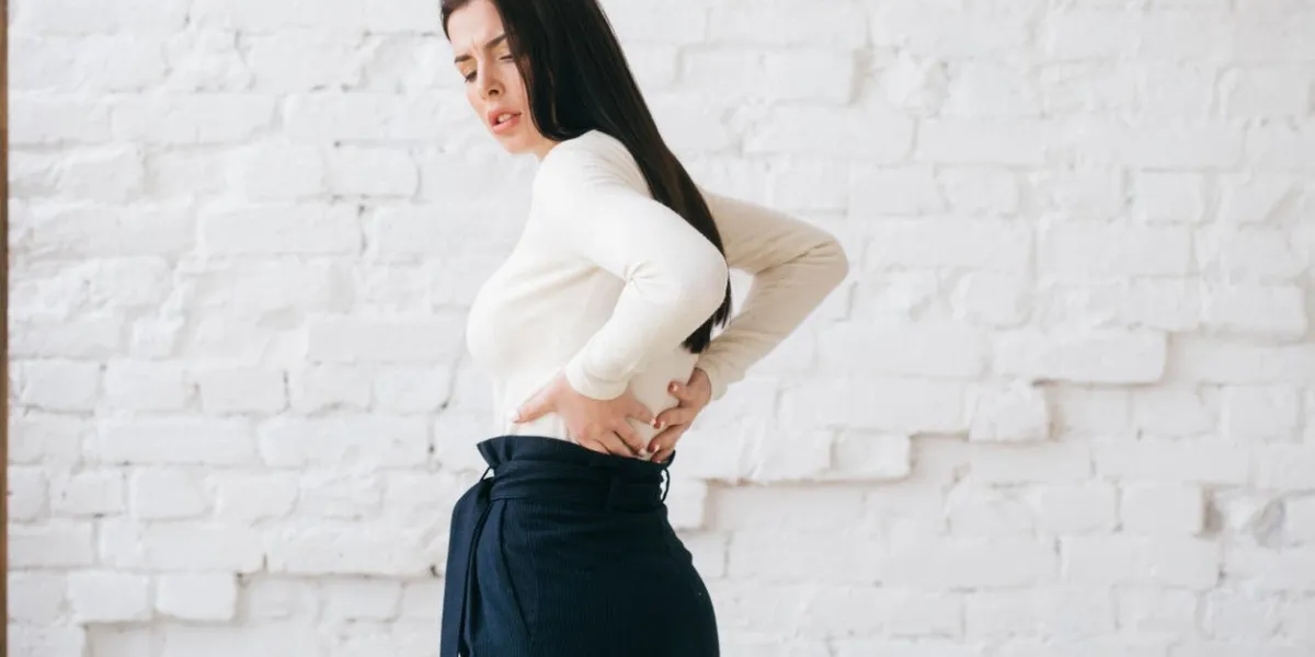 adult woman with back pain natural indoors portrait studio shot