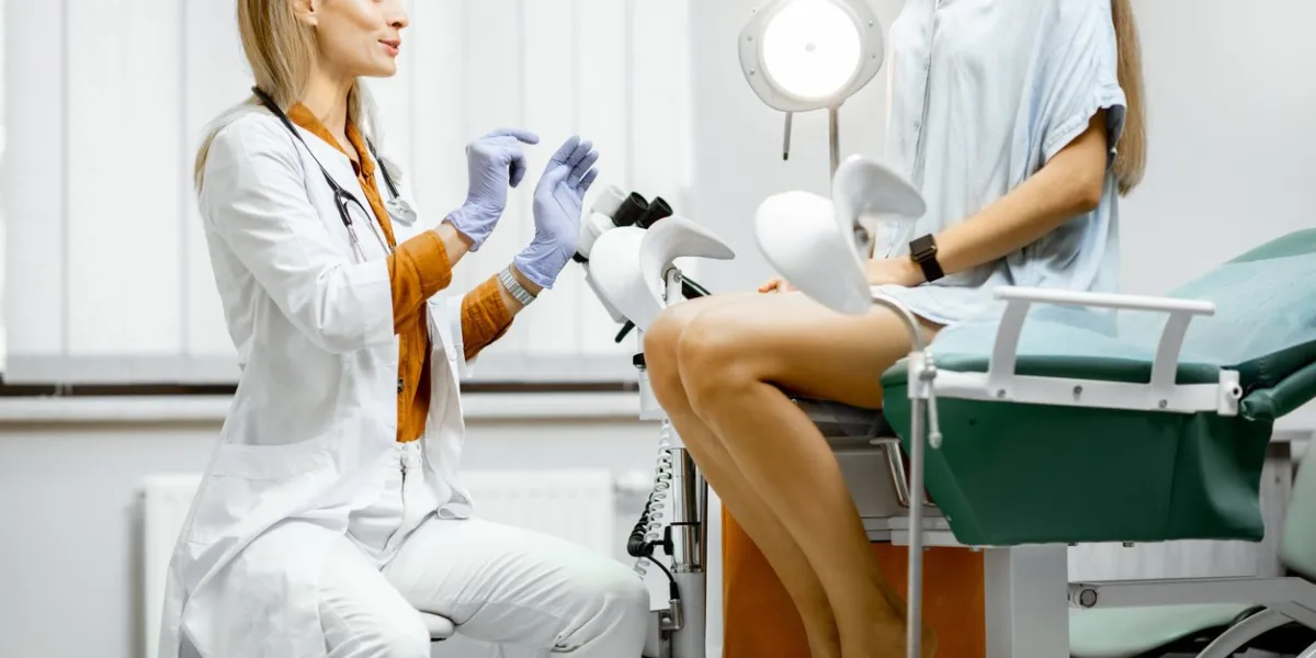 gynecologist preparing for an examination procedure for a pregnant woman sitting on a gynecological chair in the office