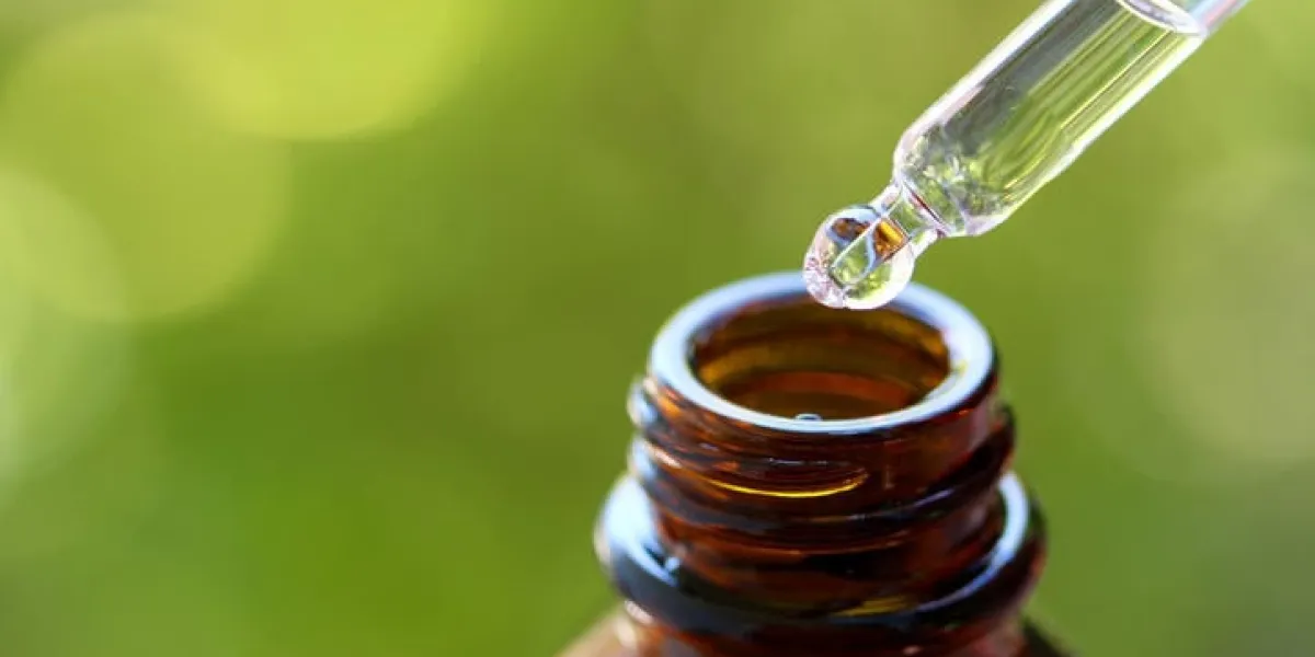 le gros plan du compte-gouttes et de la bouteille en verre brun