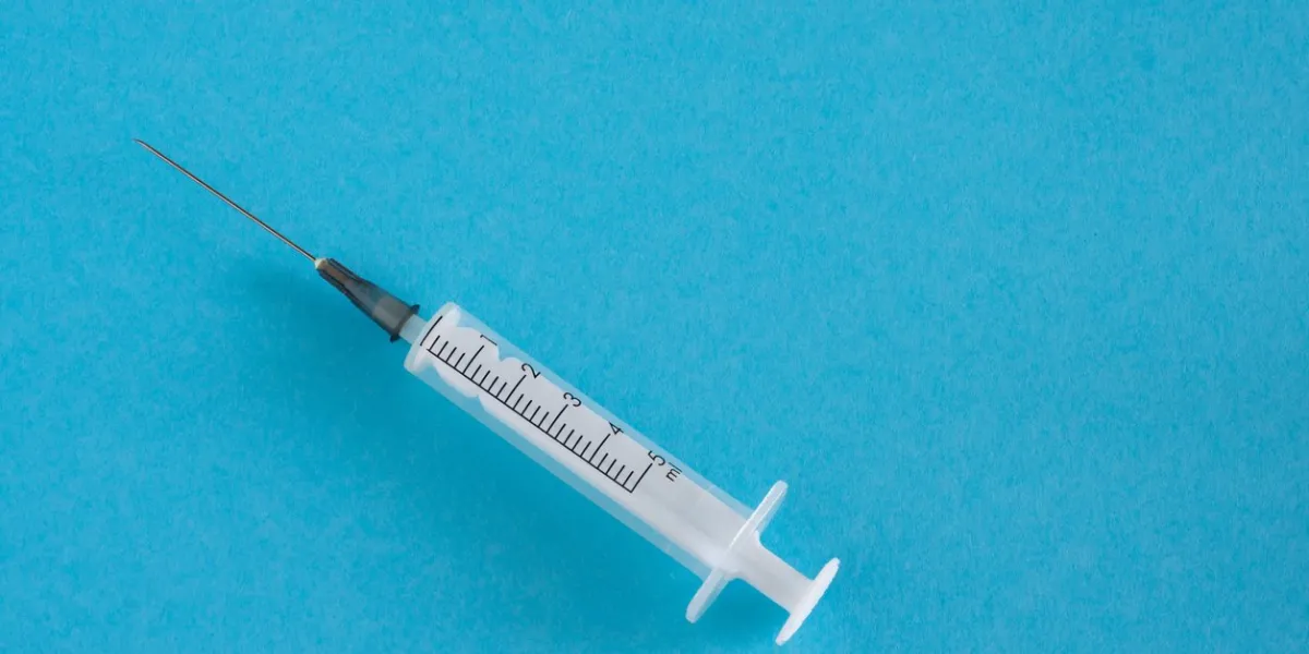 syringe isolated on blue background medicine