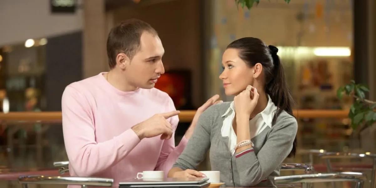le gars dit quelque chose à la fille derrière une petite table au café