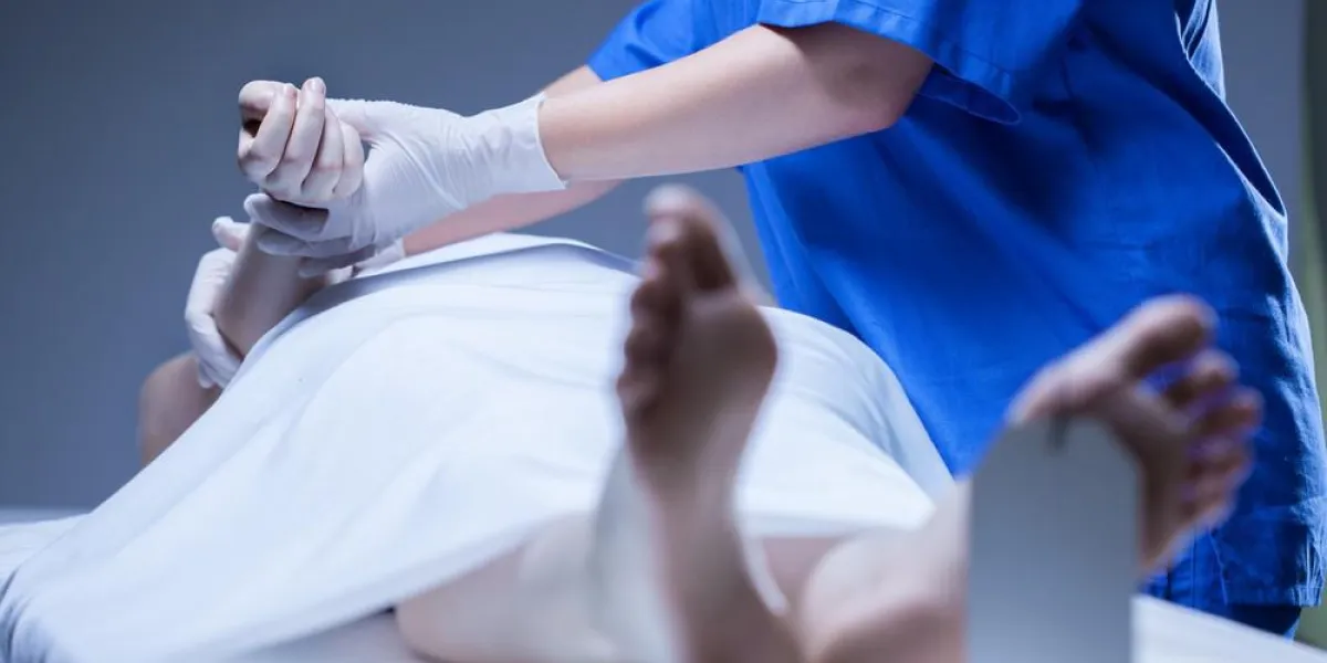 ouvrier de la morgue allongé sur le corps du cadavre