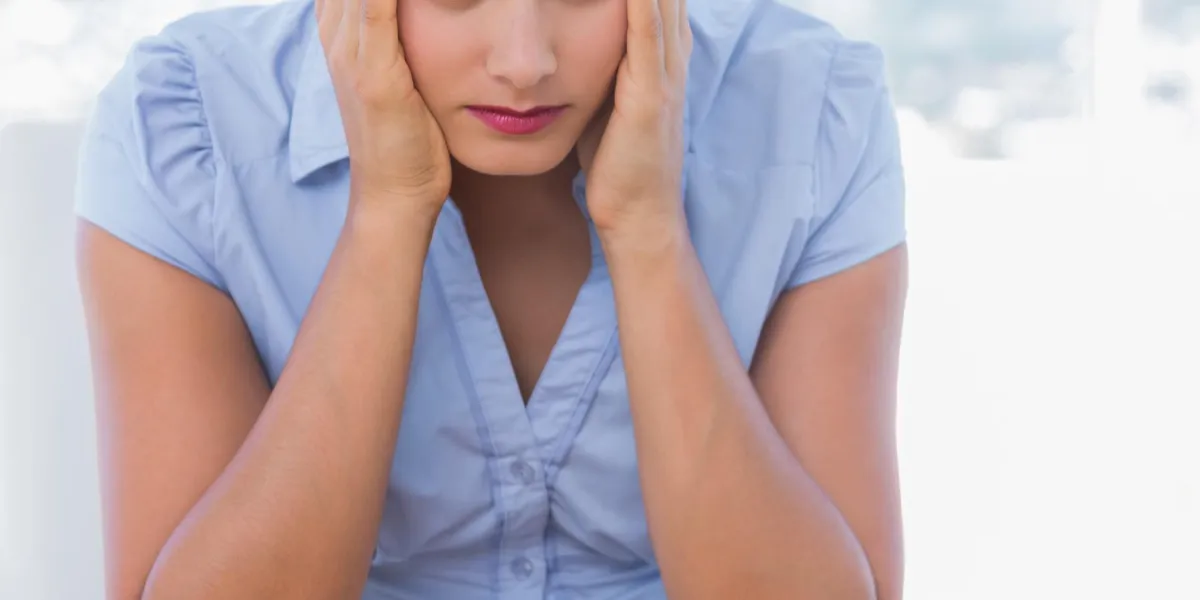 femme d'affaires anxieux ayant sa tête dans les mains dans son bureau