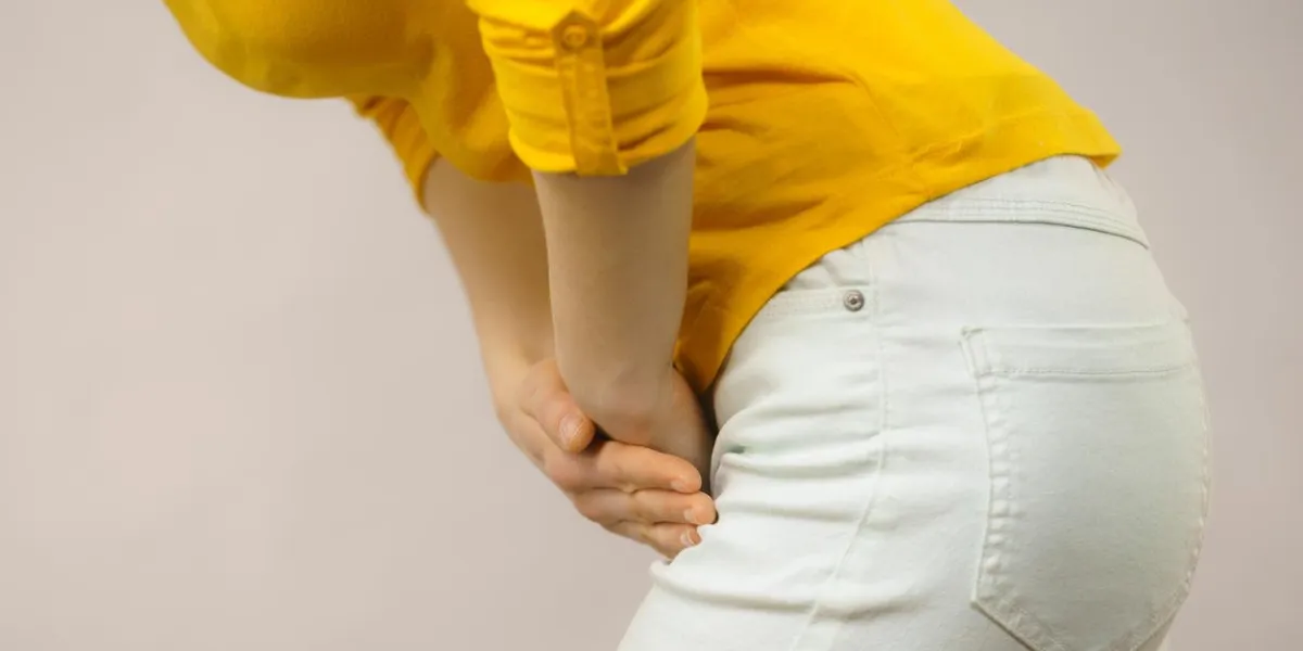 closeup young sick woman with hands holding pressing her crotch lower abdomen medical or gynecological problems, healthcare concept