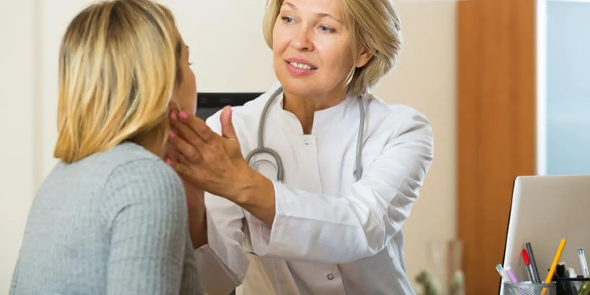 médecin mature faisant l'examen de patient malade au bureau