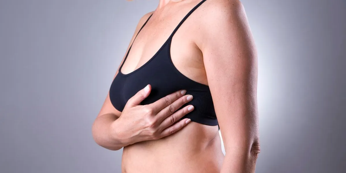 test du sein, femme examinant ses seins pour le cancer, crise cardiaque sur fond gris