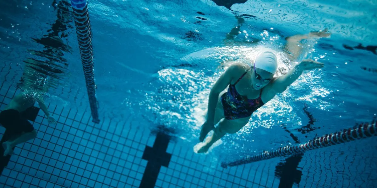 underwater shot of young female swimmer swimming in pool young female swimmer training in the pool