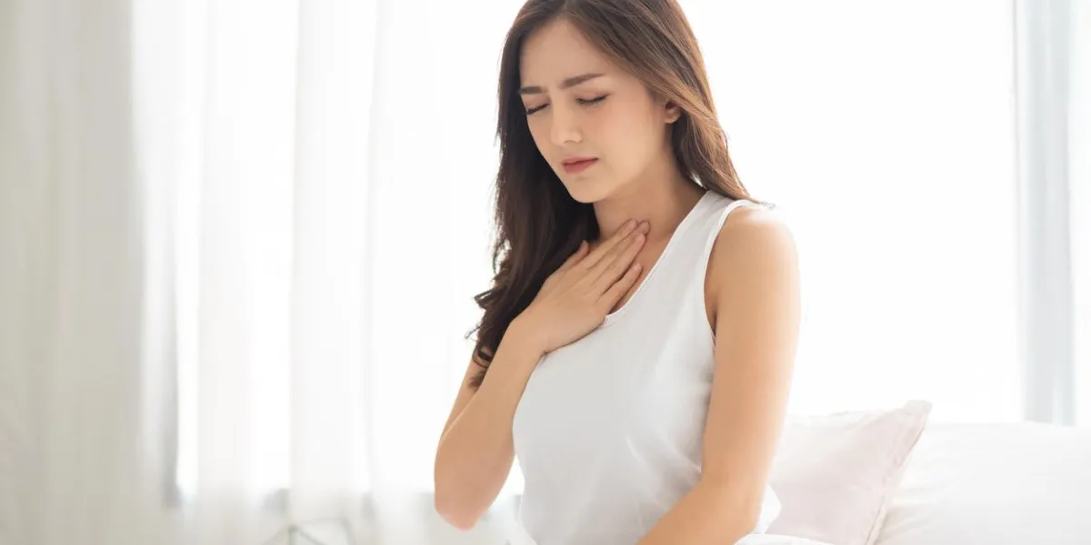 asian beautiful woman with acid reflux on her bed illness, disease, symptom