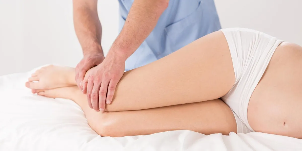 kinésithérapeute faisant des jambes de femme enceinte massage