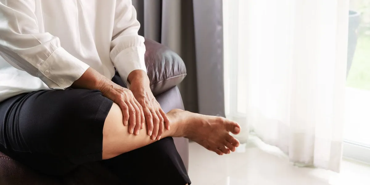 leg cramp, senior woman suffering from leg cramp pain at home, health problem concept