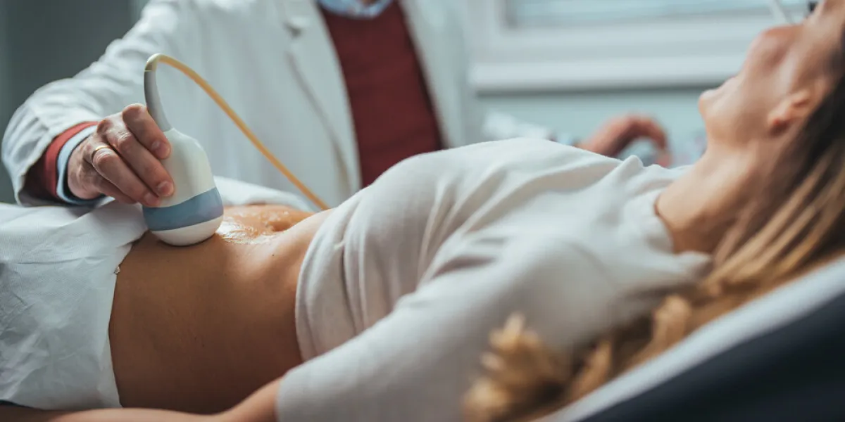 mid adult male doctor using ultrasound scanner ultrasound exam doctor's hands on a woman's stomach, ultrasound of the abdominal cavity, close-up diagnosis of diseases of the genitourinary system