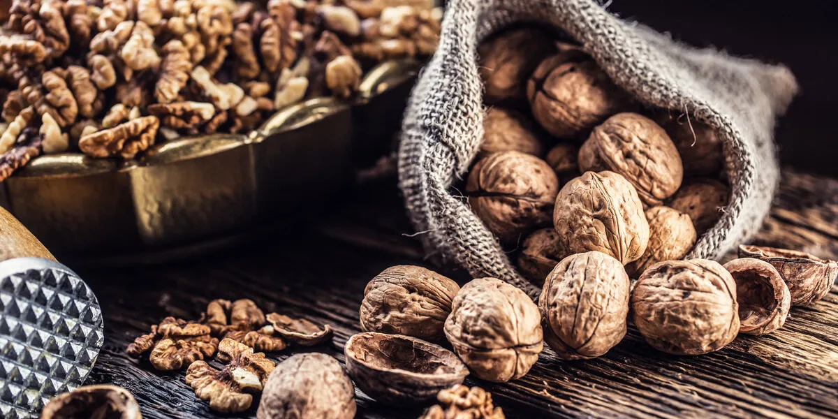walnut kernels whole walnuts in burlap sack and vintage bowl