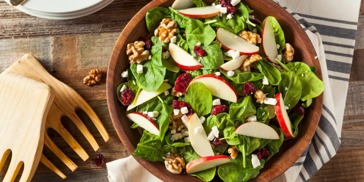 homemade autumn apple walnut spinach salad with cheese and cranberries