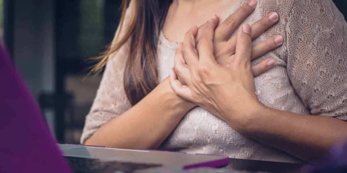 closeup woman having heart attack woman touching breast and having chest pain after long hours work on computer office syndrome concept