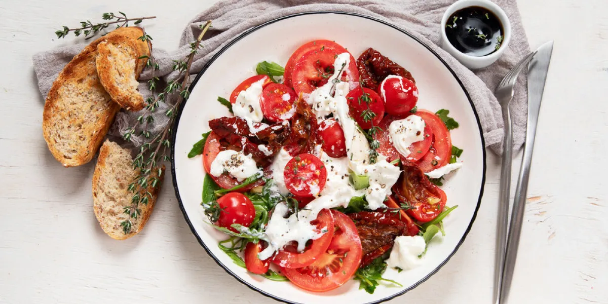 tomato, basil, mozzarella caprese salad with olive oil top view, white background