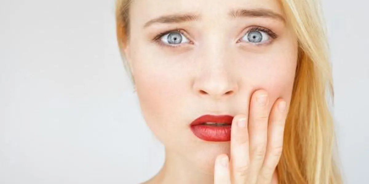 choqué et étonné portrait de femme rousse attrayant fille de carotte toucher sa joue en état de choc de l'information, espace libre
