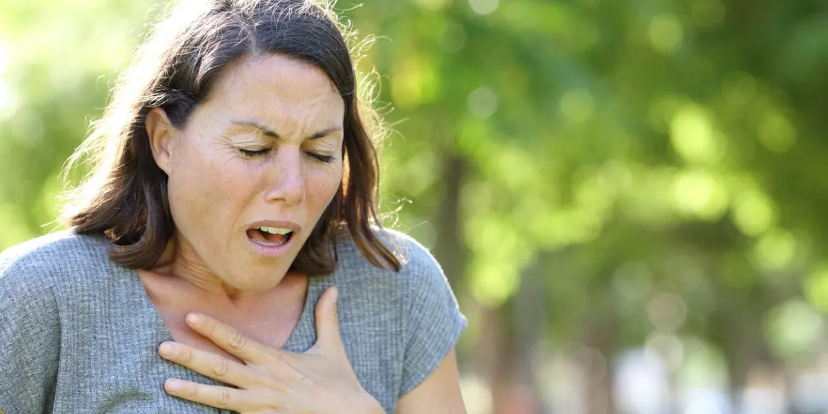 middle age woman wheezing in a park