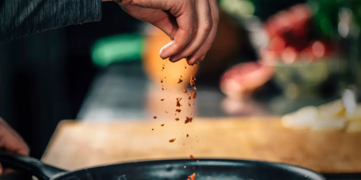sprinkling ground red chili pepper paprika over sliced vegetables, motion blur