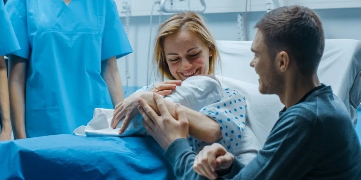 in the hospital mother hold newborn baby, supportive father lovingly hugging baby and wife happy family in the modern delivery ward