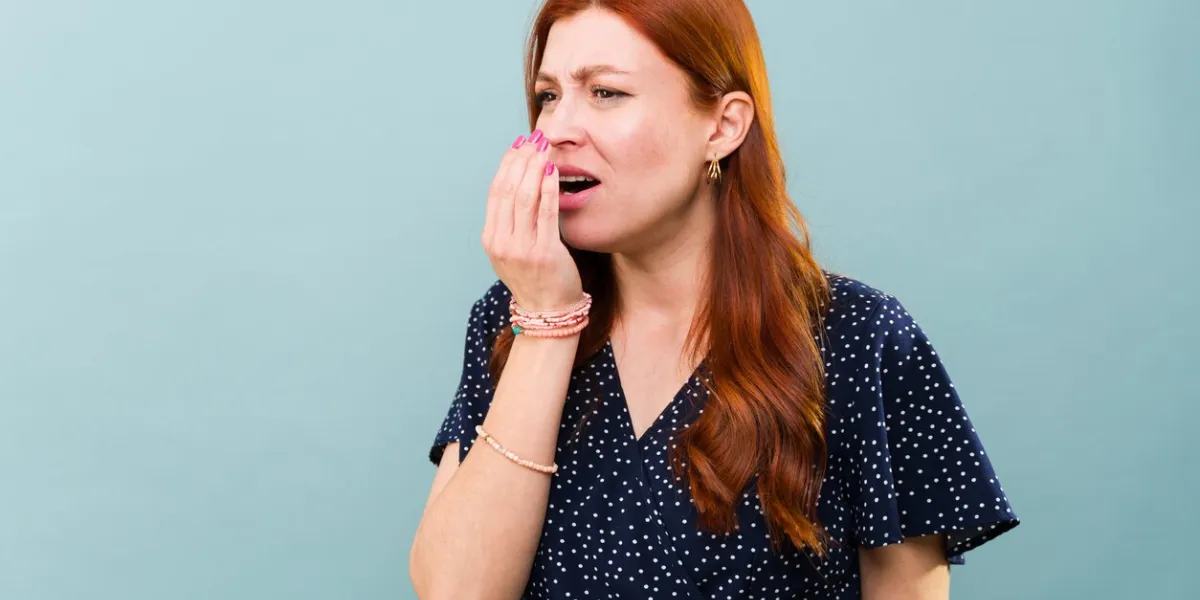 worried caucasian redhead woman with bad breath and sick with mouth halitosis
