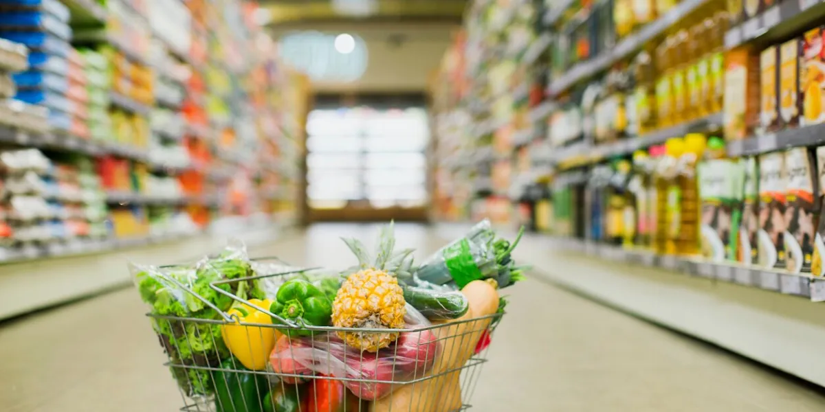 close up of full shopping basket on floor of grocery store