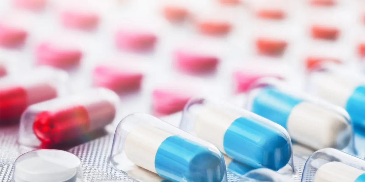 heap of medical pills in white, blue and other colors pills in plastic package concept of healthcare and medicine