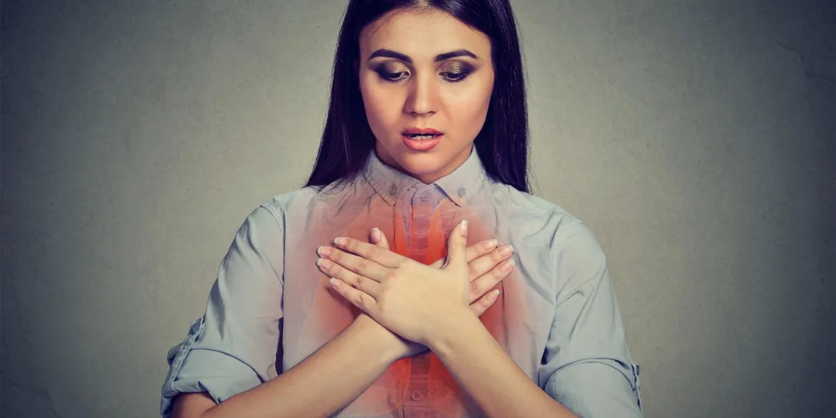 jeune femme avec une crise d'asthme ou un problème respiratoire isolé sur fond gris