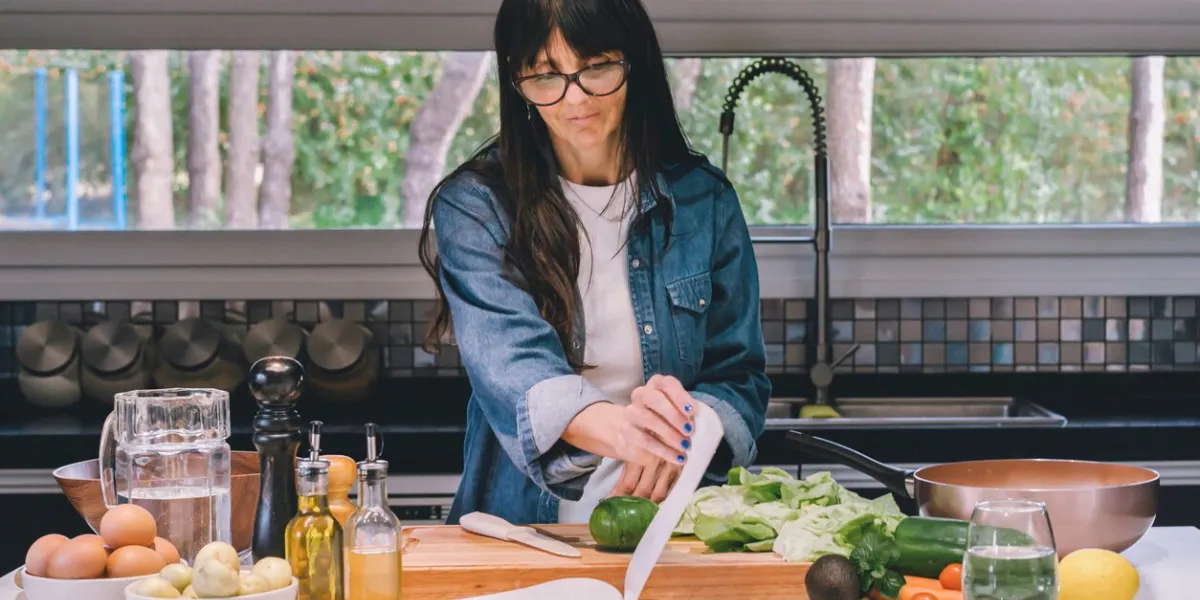 mid-adult woman reading recipe while preparing food in the kitchen
