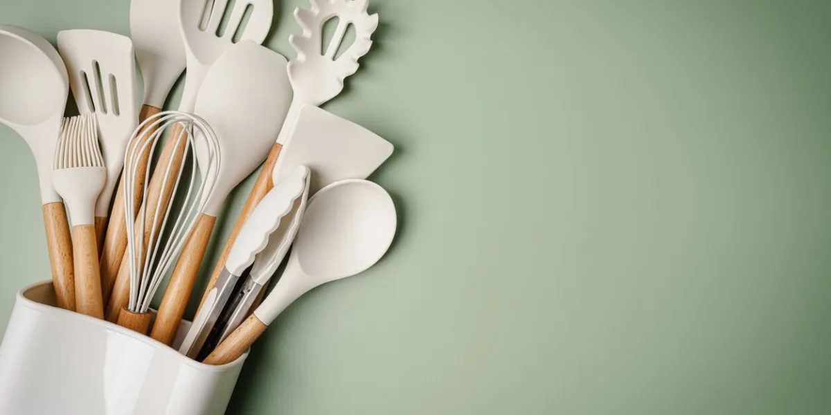 kitchen silicone utensils for cooking tools on green background, top view, flat lay kitchenware collection with copy space cooking background