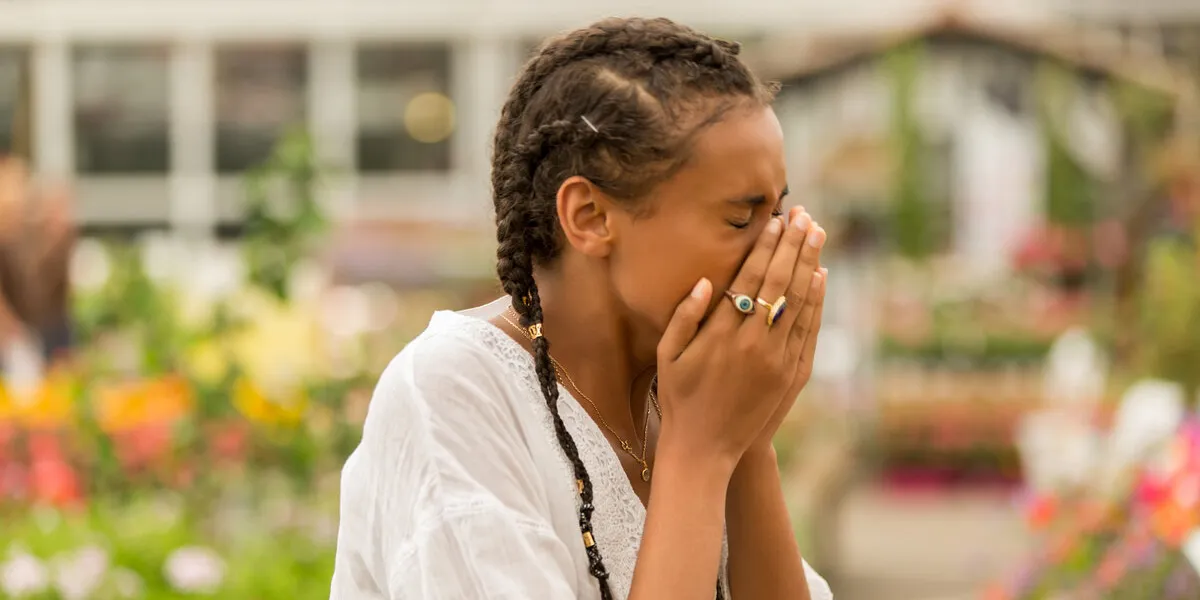 woman with allergy symptom blowing nose