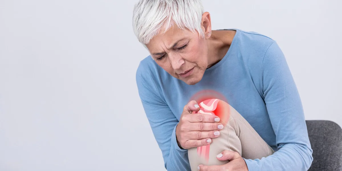 senior woman holding the knee with pain old age, health problem and people concept - senior woman suffering from pain in leg at home elderly woman suffering from pain in knee at home