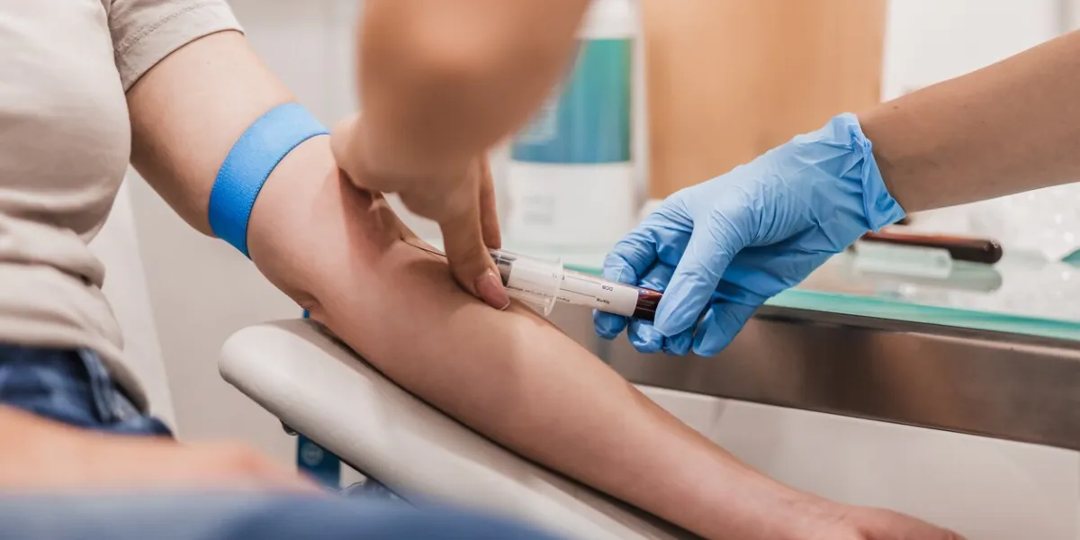 close-up of doctor taking blood sample from patient's arm in hospital for medical testing