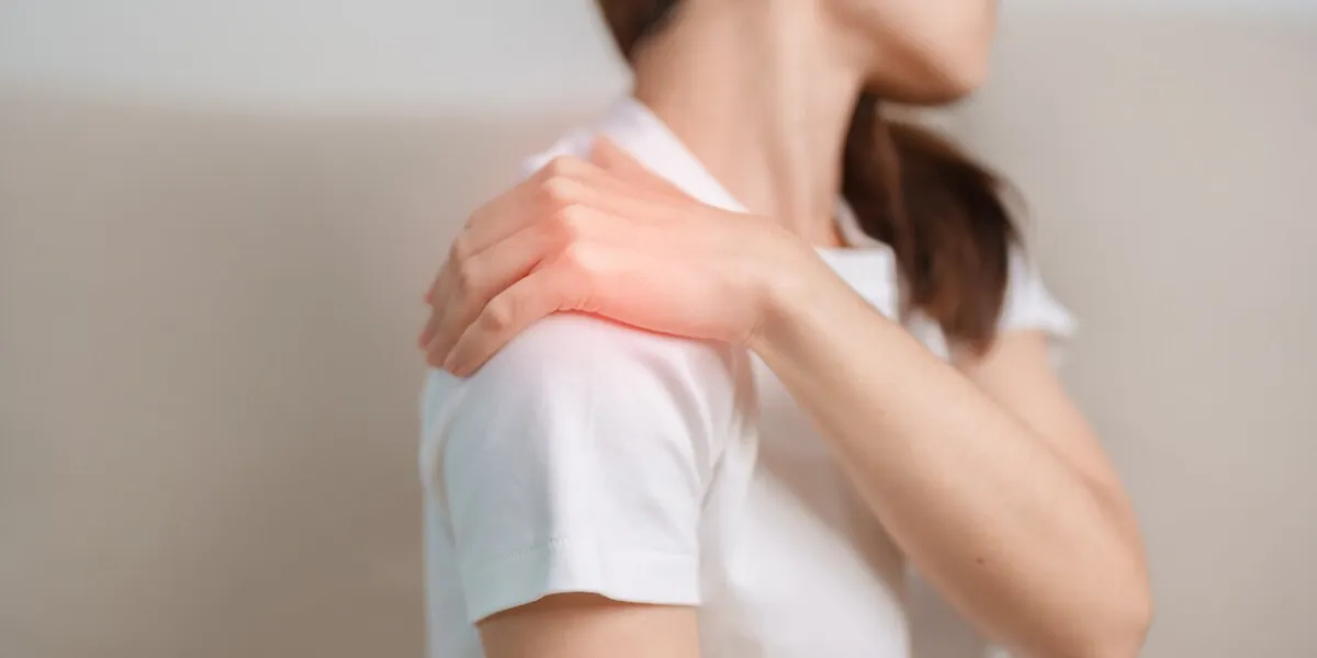 woman having shoulder and neck pain during sitting on couch at home muscle painful due to myofascial pain syndrome and fibromyalgia, rheumatism, scapular pain, cervical spine ergonomic concept