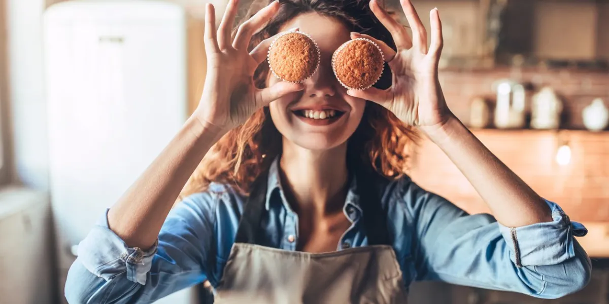 attractive young woman is cooking on kitchen having fun while making cakes and cookies