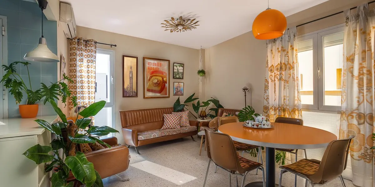 malaga, spain circa february 2018vintage decoration with a retro sofa, old movies posters, macrame plant hangers, retro print cushions