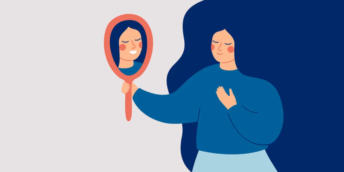 young woman looks at the mirror and sees her happy reflection self-acceptance and confidence concept