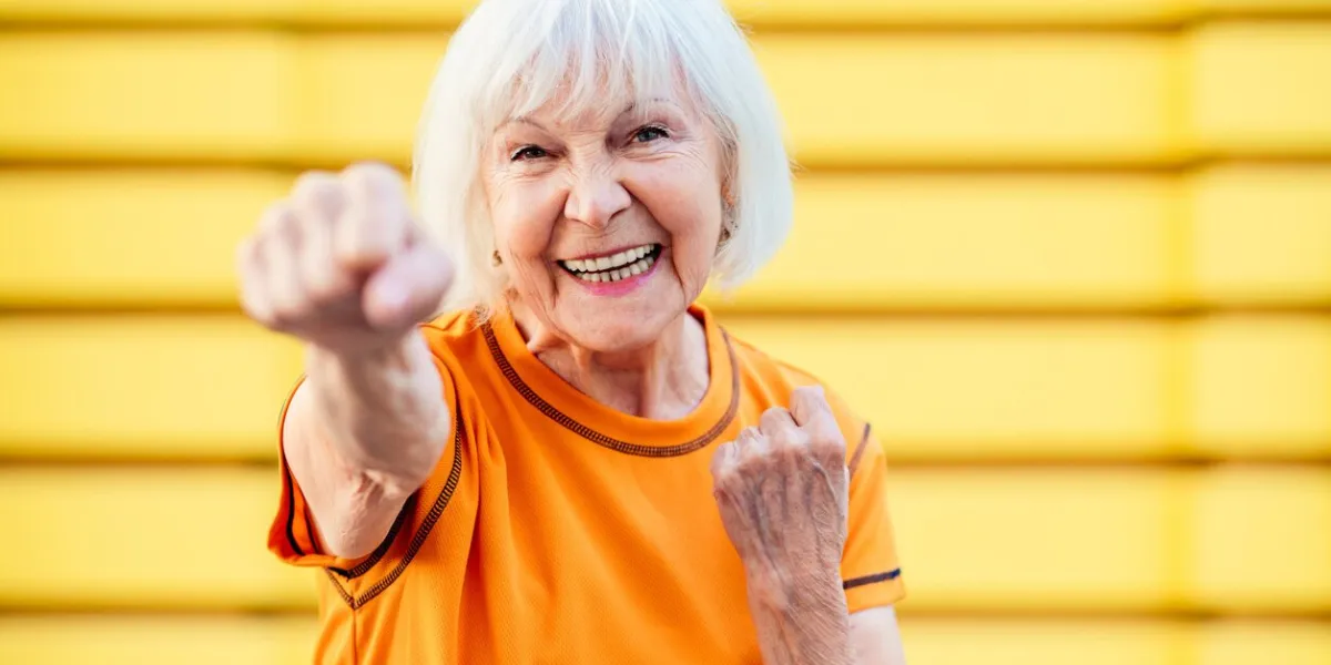 beautiful sportive senior woman training outdoors - mature adults old female doing fitness workout exercises in a park to stay healthy and fit