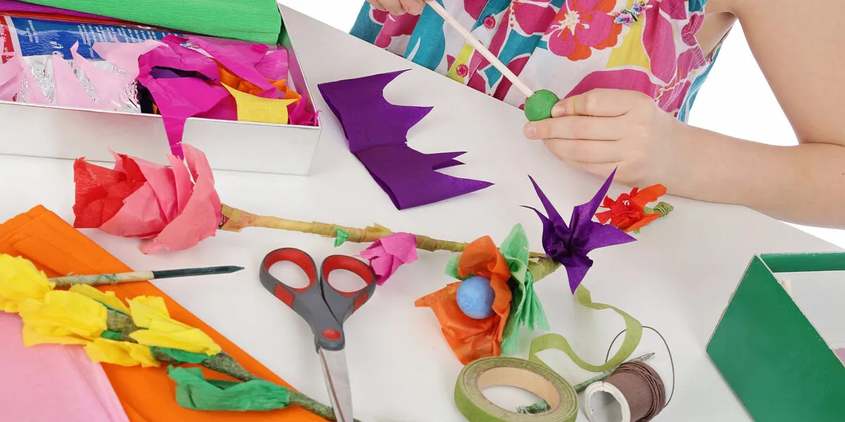 fillette fabriquant fleurs en papier crépon