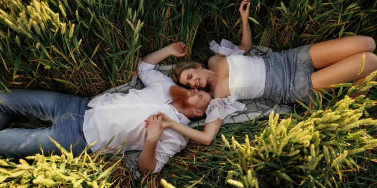 top view, lying down lovely couple are on the green agricultural field together