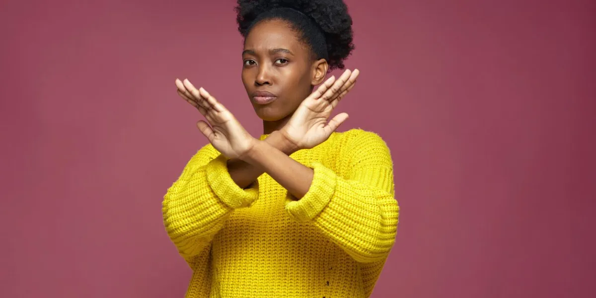 serious young african american woman showing stop finish gesture by crossed hands, protesting against gender and racial discrimination protests high quality photo