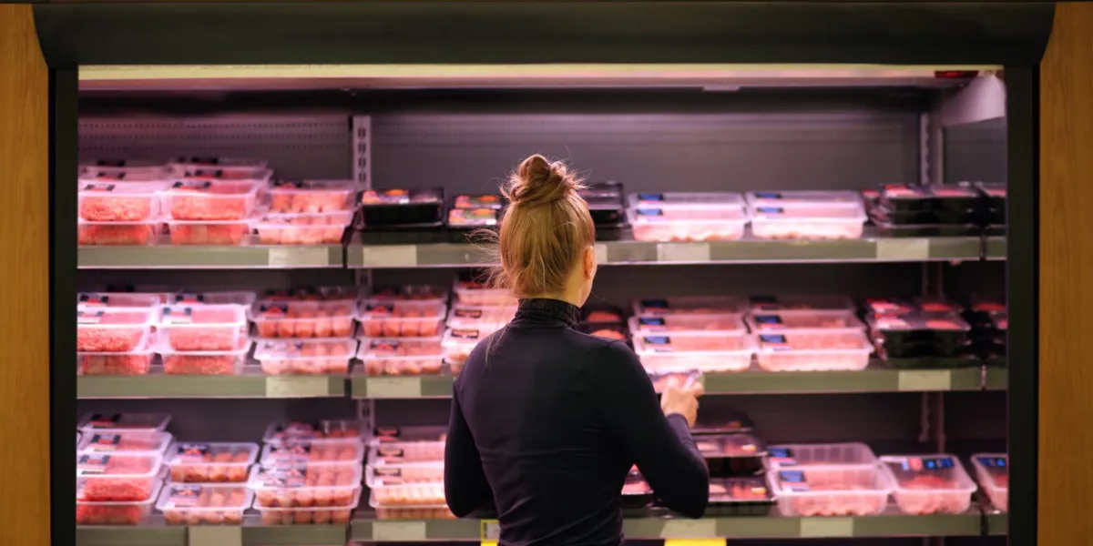 woman purchasing a packet of meat at the supermarket