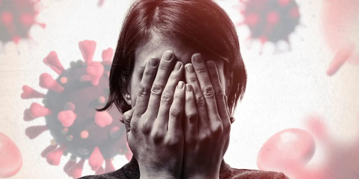concept of fear of coronavirus woman covers her face her hands on background with coronavirus