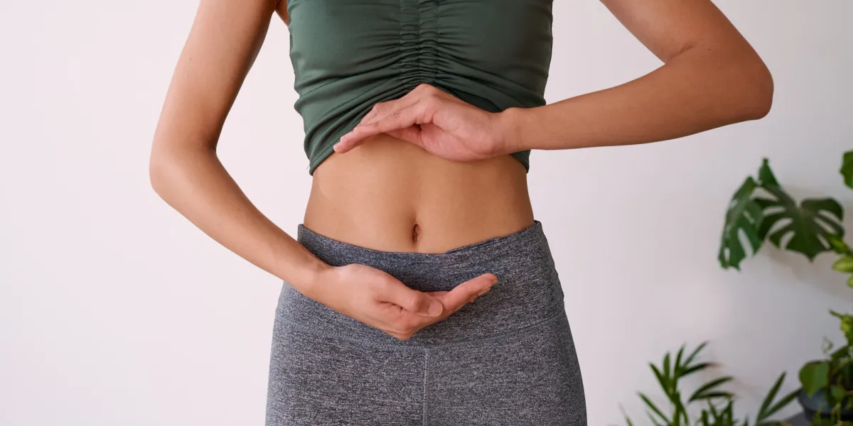 close up of a young multi-ethnic woman's stomach cupped by her hands high quality photo