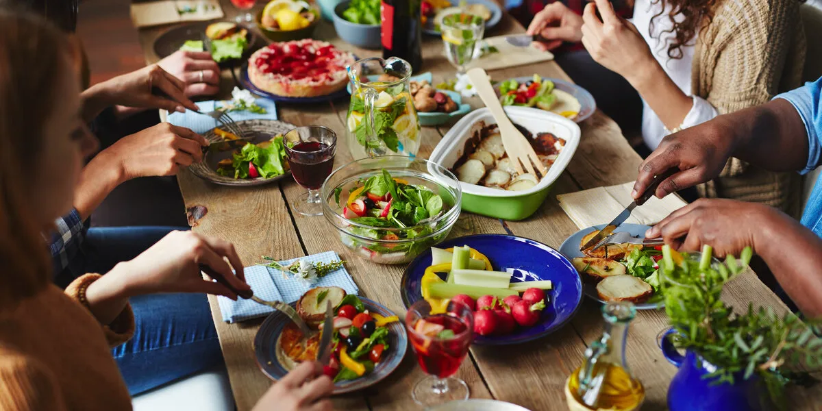 hungry people eating appetizing vegetarian dinner