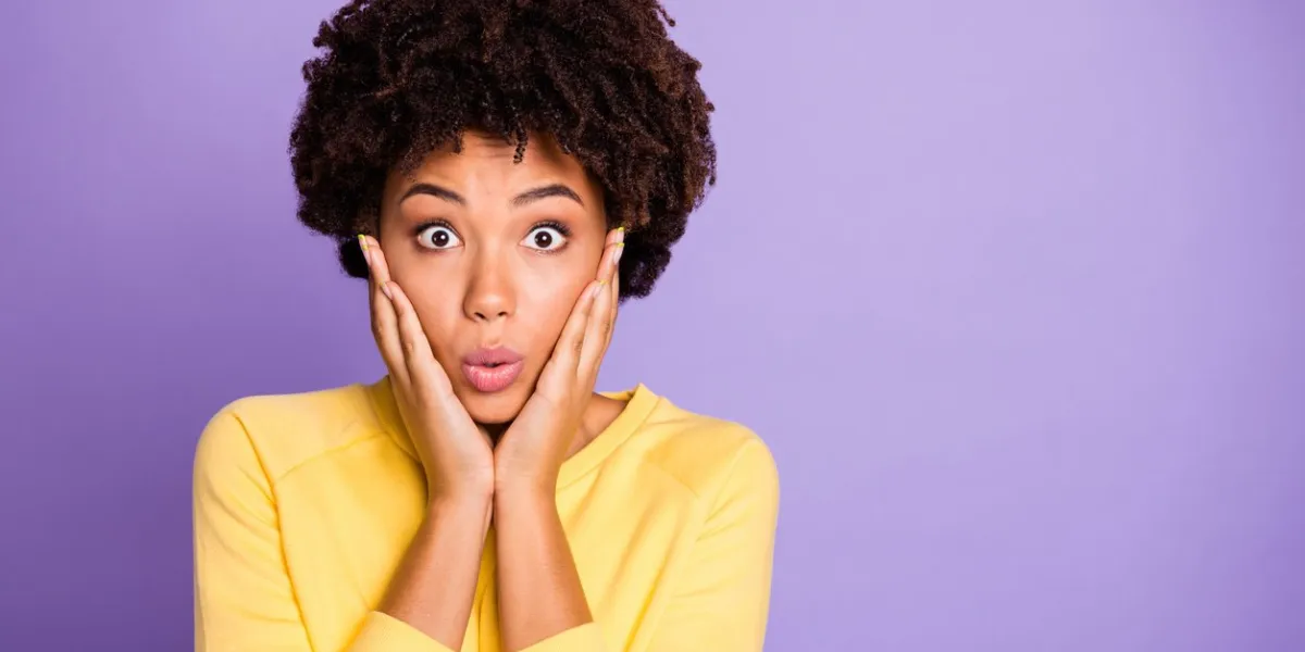 photo of terrified stunned shocked girlfriend touching her cheekbones, pouting her lips noticing her cheeks enlarged isolated over purple pastel color background